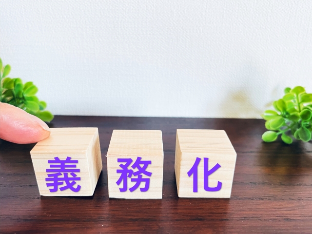 義務化の文字列が書かれた積み木