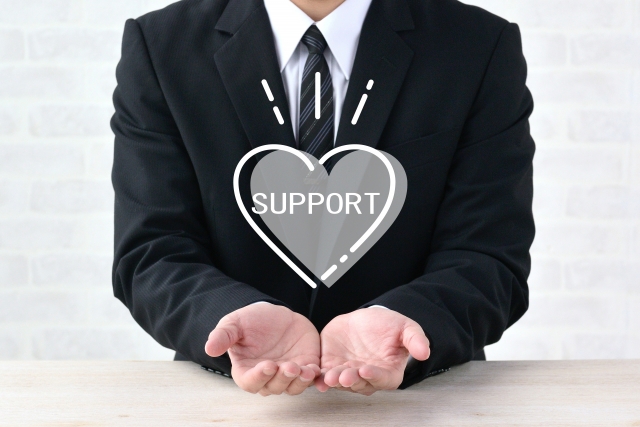 SUPPORTの文字列が書かれたハートのマークとスーツ姿の男性