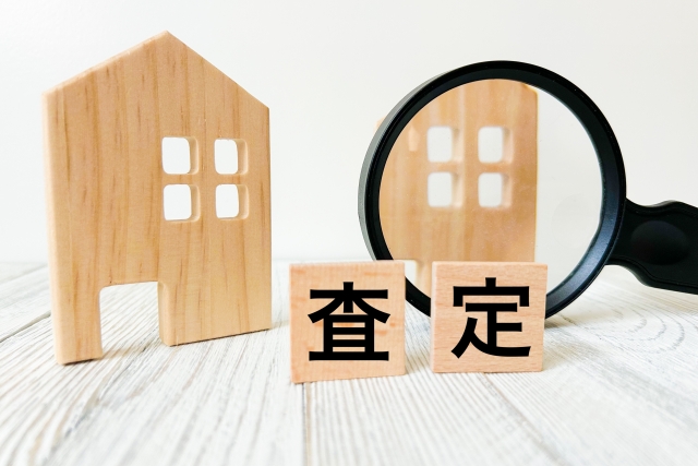 査定の文字列が書かれた積み木と虫眼鏡