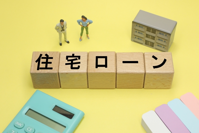 住宅ローンの文字列が書かれた積み木と計算機